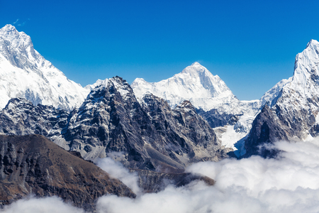 The peak of the snowy mountains in the cloudsの写真素材