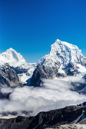 The peak of the snowy mountains in the cloudsの写真素材