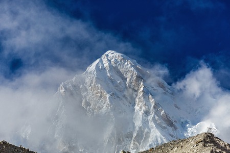 The peak of the snowy mountains in the cloudsの写真素材