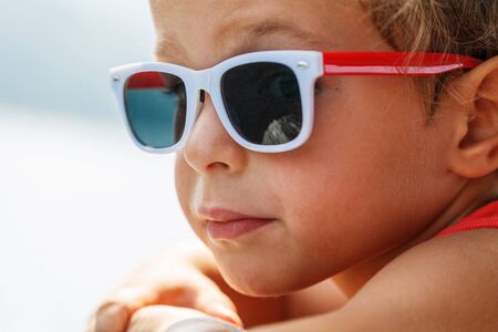 Portrait of a beautiful boy in sunglasses and capの写真素材