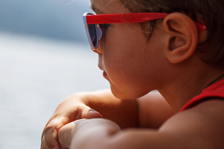 Portrait of a beautiful boy in sunglasses and capの写真素材