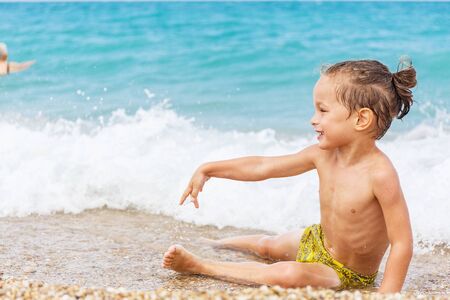 Beautiful boy is playing with the blue seaの写真素材