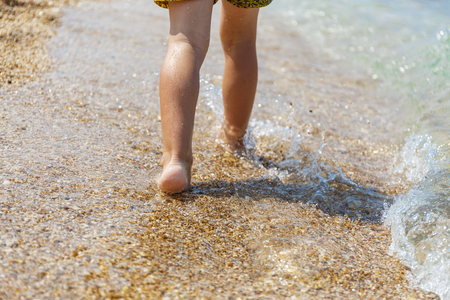 Little feet walking in the blue seaの写真素材