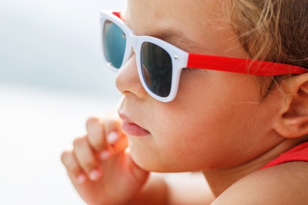Portrait of a beautiful boy in sunglasses and capの写真素材