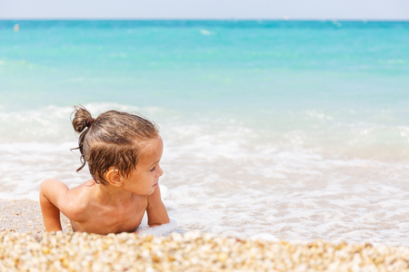 Beautiful boy is playing with the blue seaの写真素材