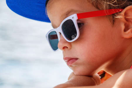 Portrait of a beautiful boy in sunglasses and capの写真素材