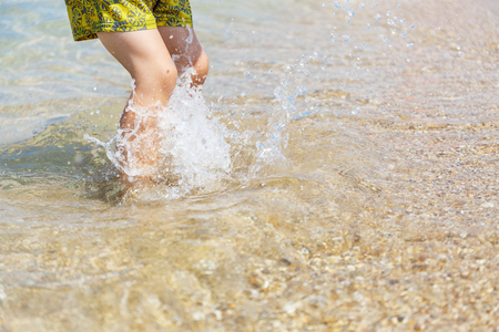 Little feet walking in the blue seaの写真素材
