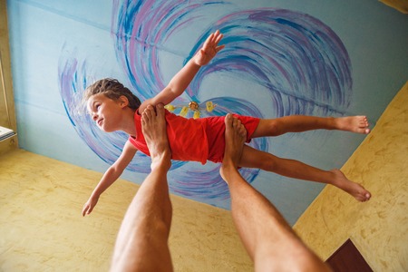 Flying boy like super hero on the blue ceiling backgroundの写真素材