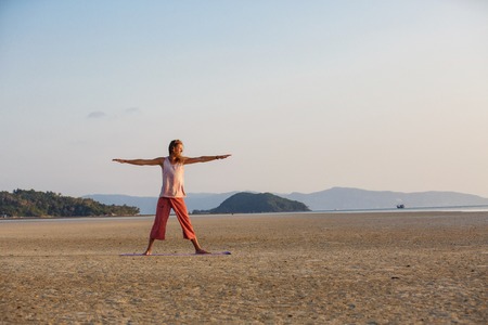 Man is doing yoga on the beachの写真素材