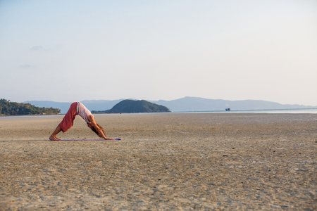 Man is doing yoga on the beachの写真素材