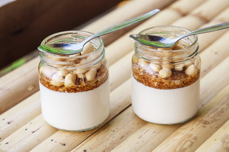 Glass jars with delicious yogurt and nutsの写真素材