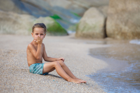 boy sitting on the sand by the seaの写真素材