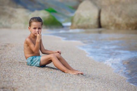 boy sitting on the sand by the seaの写真素材