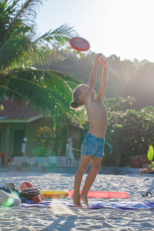 Boy playing flying disk on the beachの写真素材