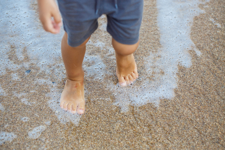 little legs of a boy walking on the beachの写真素材