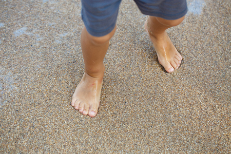 little legs of a boy walking on the beachの写真素材