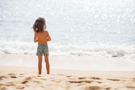 Little five years old boy is watching on the seaの写真素材