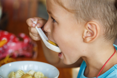 beautiful boy is having breakfast with  porridgeの写真素材