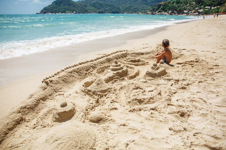 little boy built a sand castleの写真素材