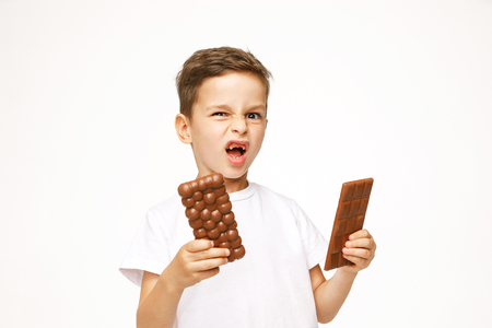 little boy with two chocolates on a white backgroundの写真素材