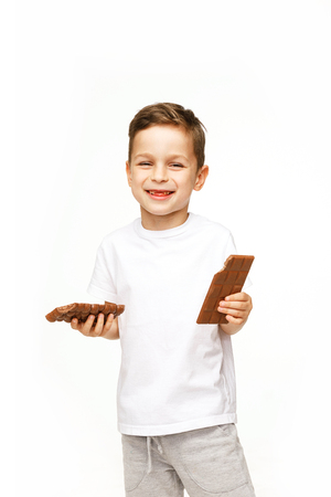 little boy with two chocolates on a white backgroundの写真素材