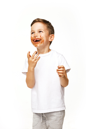 little boy with face and hands in chocolateの写真素材