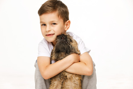little boy is hugging the dog studio shotの写真素材