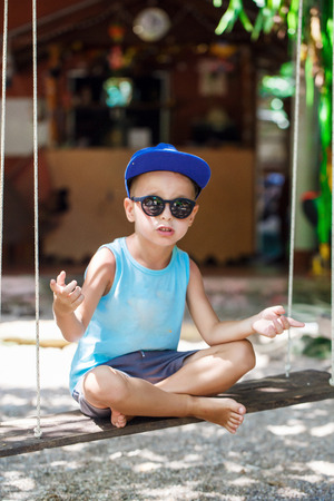 little boy is sitting on a swingの写真素材