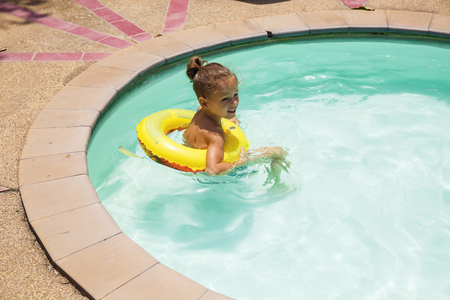 Baby boy is swimming in the poolの写真素材