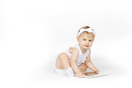 little girl all in white with a tabletの写真素材