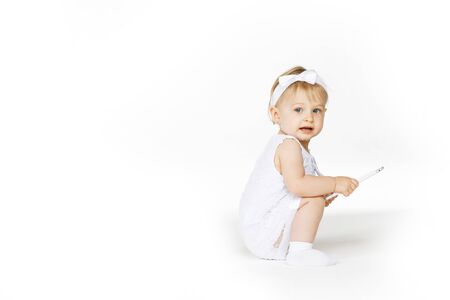 little girl all in white with a tabletの写真素材
