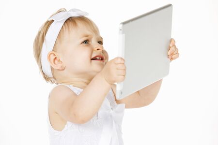 little girl all in white with a tabletの写真素材