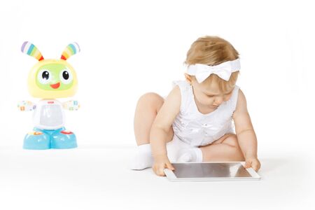 little girl all in white with tablet and toyの写真素材