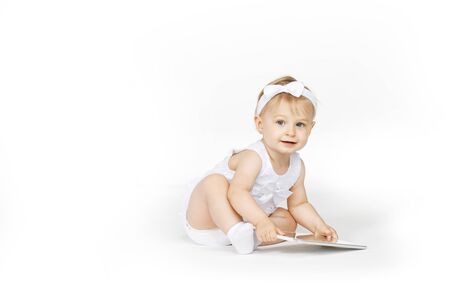 little girl all in white with a tabletの写真素材