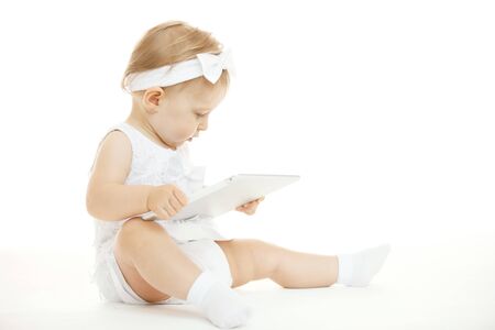 little girl all in white with a tabletの写真素材
