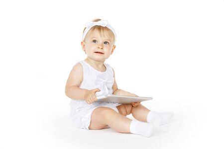little girl all in white with a tabletの写真素材