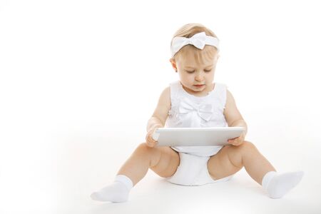 little girl all in white with a tabletの写真素材