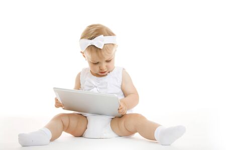 little girl all in white with a tabletの写真素材
