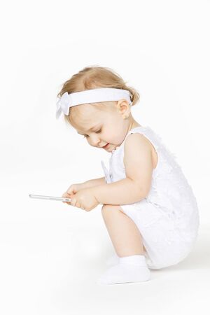 little girl all in white with a tabletの写真素材