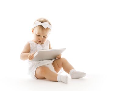 little girl all in white with a tabletの写真素材