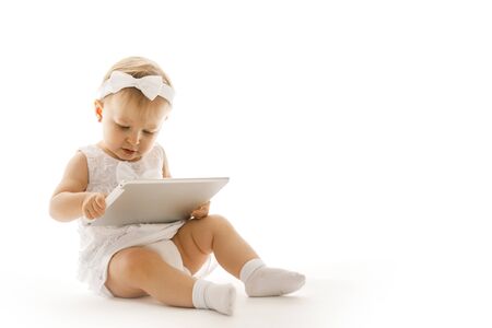 little girl all in white with a tabletの写真素材