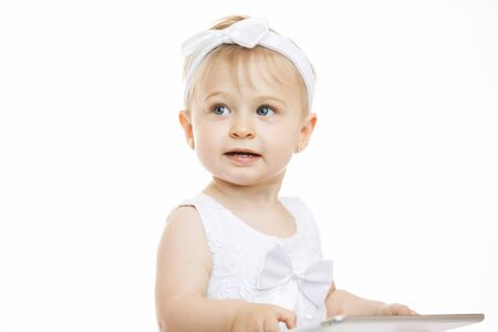 little girl all in white with a tabletの写真素材
