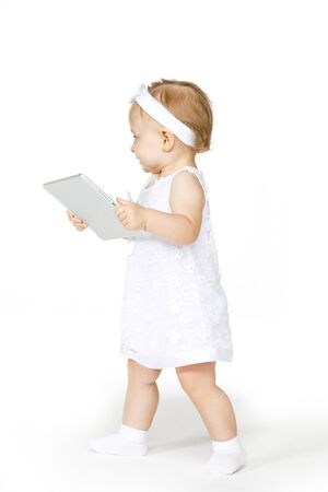 little girl all in white with a tabletの写真素材