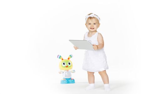 little girl all in white with tablet and toyの写真素材