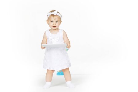 little girl all in white with a tabletの写真素材