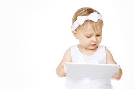 little girl all in white with a tablet on white backgroundの写真素材