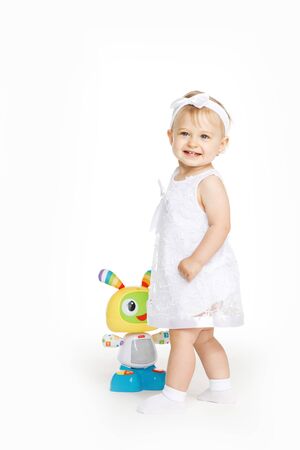 beautiful little girl all in white clothes with a toyの写真素材