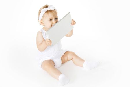 little girl all in white with a tabletの写真素材