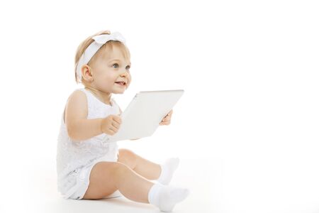 little girl all in white with a tabletの写真素材