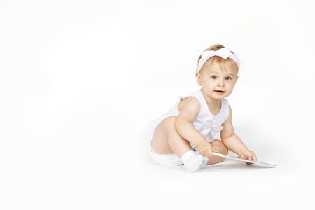 little girl all in white with a tabletの写真素材